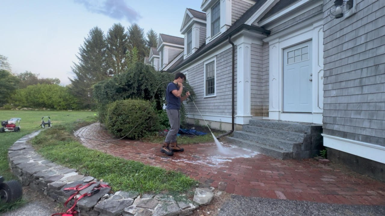 Cleaning a brick walkway in front of a home